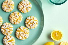 lemon cookies are on a plate next to sliced lemons