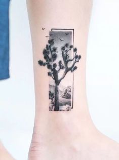 a small tattoo on the ankle of a woman's foot with a tree and birds