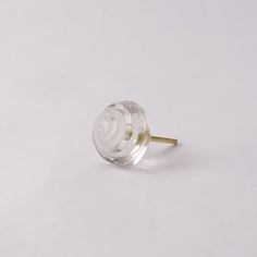 a glass knob with a gold handle on a white surface