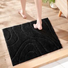 a person standing on the floor in front of a black rug