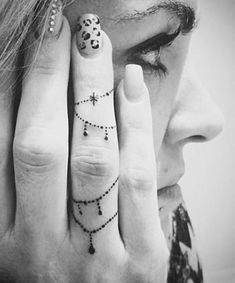 a woman holding her hand up to her face with the words new piercings on it