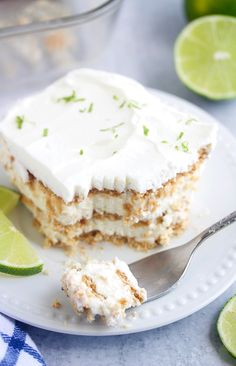 a close up of a piece of cake on a plate with limes around it