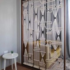 a room divider made out of white string and wood with an arrow pattern on it