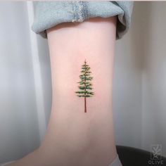 a small pine tree tattoo on the ankle