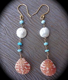 two seashells with pearls and turquoise beads are hanging from gold earwires