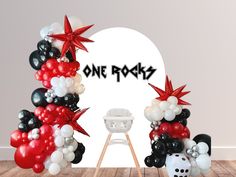 a balloon arch with balloons and decorations for a one rock themed baby's first birthday