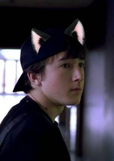 a young man wearing a cat hat with ears