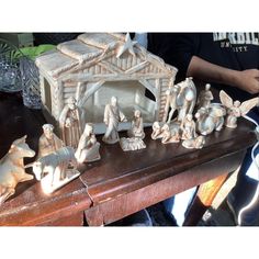 a group of figurines sitting on top of a wooden table next to a nativity scene