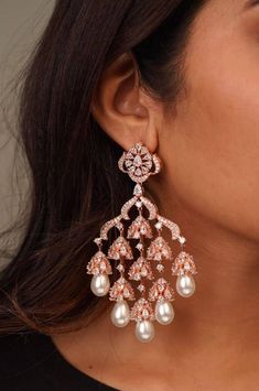 Stunning Fluttery CZ stones gives the right amount of sparkle you need for these gorgeous chaandbali earrings With Pearl hangings  Available in Rose Gold/Silver Polish Length: Approx 3.5 inches Lightweight Closure: Pushback Customized orders takes 3 to 4 weeks, depending on piece requirements. The Ombre Designs Jewelry pieces can be customized in accordance with your requirement. Please Email or Whats app on : +91 8448833193 / sonalikamehra [!at] theombredesigns.com Rose Gold And Pearl Earrings, Luxury Bollywood Pearl Earrings With Latkans, Luxury Yellow Gold Chandbali Pearl Earrings, Luxury Chandbali Earrings For Reception, Luxury Elegant Earrings For Diwali, Luxury Elegant Chandbali Earrings, Luxury Chandbali Danglers For Party, Luxury Festive Pearl Earrings With Latkans, Luxury Kundan Bollywood Chandelier Earrings