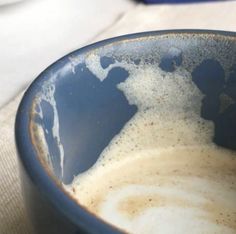 a blue bowl filled with liquid on top of a table