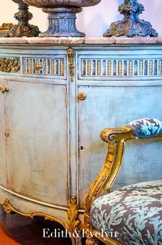 an ornately decorated sideboard and chair in a room