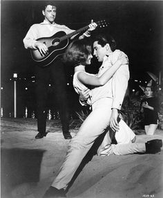 an old black and white photo of two people playing guitar