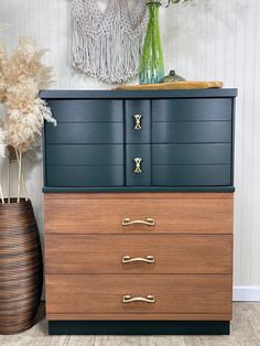 a dresser with three drawers and two vases