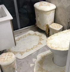 a white toilet sitting next to a sink in a bathroom under a shower curtain with gold designs on it