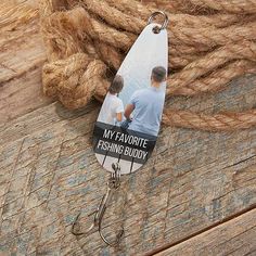 a fishing hook with an image of two men on it and rope in the background