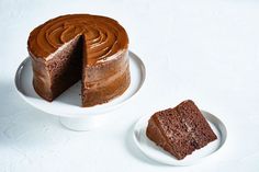 a chocolate cake on a plate with one slice cut out and the other half eaten