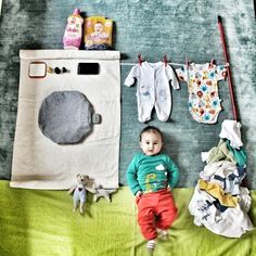 a baby laying on top of a bed next to clothes