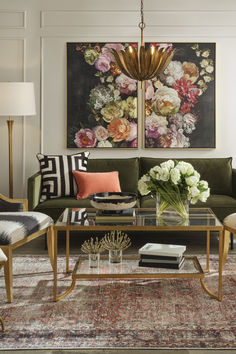 a living room filled with furniture and paintings on the wall above it's coffee table