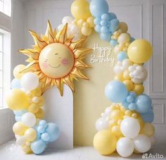 an arch made out of balloons with a smiling sun on it