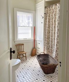 a bathroom with a basket on the floor and a toilet in the corner next to it