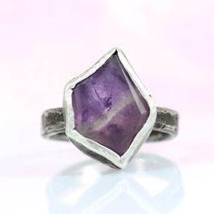 This beautiful and unique Amethyst ring is a stunning piece of rustic jewelry, featuring a semi-raw amethyst set in a rough and organic design. The hand-cut raw amethyst is perfectly showcased in a hammered bezel with intentional and natural texturing, giving it a beautiful appearance that perfectly complements the oxidized silver band. The band is crafted from reticulated silver, adding to the earthy, rustic feel of this organic ring. Whether you're a fan of raw and natural beauty or simply loo Unique Amethyst Ring, Reticulated Silver, Rock Ring, Rock Rings, Flat Rock, Amethyst Set, Organic Rings, Raw Amethyst, Organic Ring