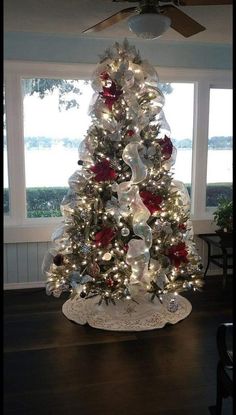 a white christmas tree with red and silver ornaments