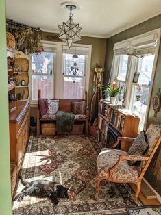 a living room filled with furniture and lots of windows next to a book shelf full of books