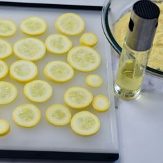 sliced up lemons on a cutting board next to a glass bowl with oil in it