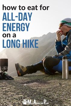 a man sitting on top of a mountain next to a backpack and an electric device