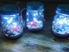 three mason jars filled with sand and sea shells