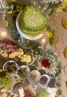 a table topped with lots of food next to wine glasses and plates filled with fruit