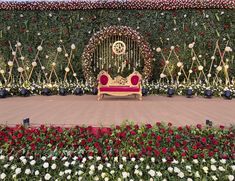 a bench sitting in the middle of a flower garden with lots of flowers around it