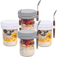 three jars with spoons in them filled with food