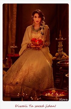 a woman sitting on a table with candles in front of her