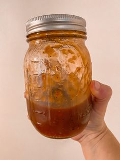 a hand holding a mason jar filled with food