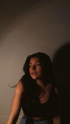 a woman is sitting on the floor with her hand in her pocket and looking up