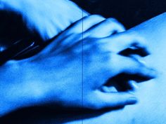 two hands touching each other in the middle of a blue photo with black and white background