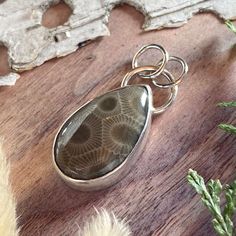 Petoskey Stone from Michigan handcrafted into a teardrop-shaped cabochon and placed in a custom, sterling silver setting. Pendant measures approximately 0.6 x 1.0 inch. Handmade Bohemian Keepsake Jewelry, Bohemian Handmade Jewelry For Keepsake, Bohemian Handmade Keepsake Jewelry, Untreated Agate Pendant Jewelry, Handmade Teardrop Jewelry, Nature-inspired, Handmade Teardrop Nature-inspired Jewelry, Handmade Earthy Pendant Jewelry, Handmade Nature-inspired Teardrop Jewelry, Handmade Earthy Sterling Silver Jewelry