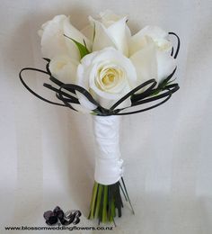 a bridal bouquet with white roses and greenery on the stems is ready to be used as a bride's bouquet