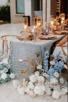 the table is set with flowers and candles