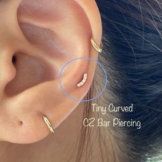 a close up of a person's ear with two different piercings on it