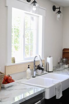 a white kitchen sink sitting under a window