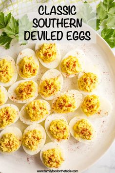 deviled eggs on a white plate with parsley