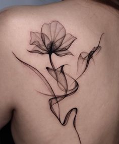 the back of a woman's shoulder with an abstract flower tattoo design on it