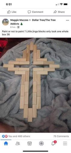 a cross made out of wooden sticks on top of a pile of blankets with the caption's tweet below it