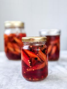 jars filled with pickled vegetables sitting on top of a table