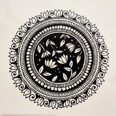 a black and white drawing of leaves in a circular design on a wall with an intricate border