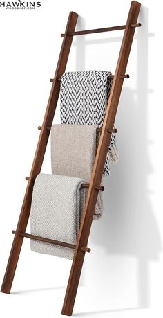 a wooden ladder with towels hanging on it's sides and two blankets folded in the bottom