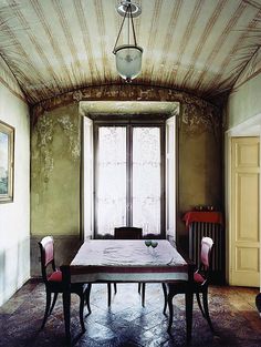 a dining room table and chairs in front of a large window with an arched ceiling