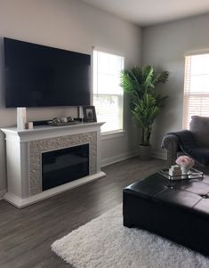 a living room with a couch, coffee table and television mounted on the wall above it